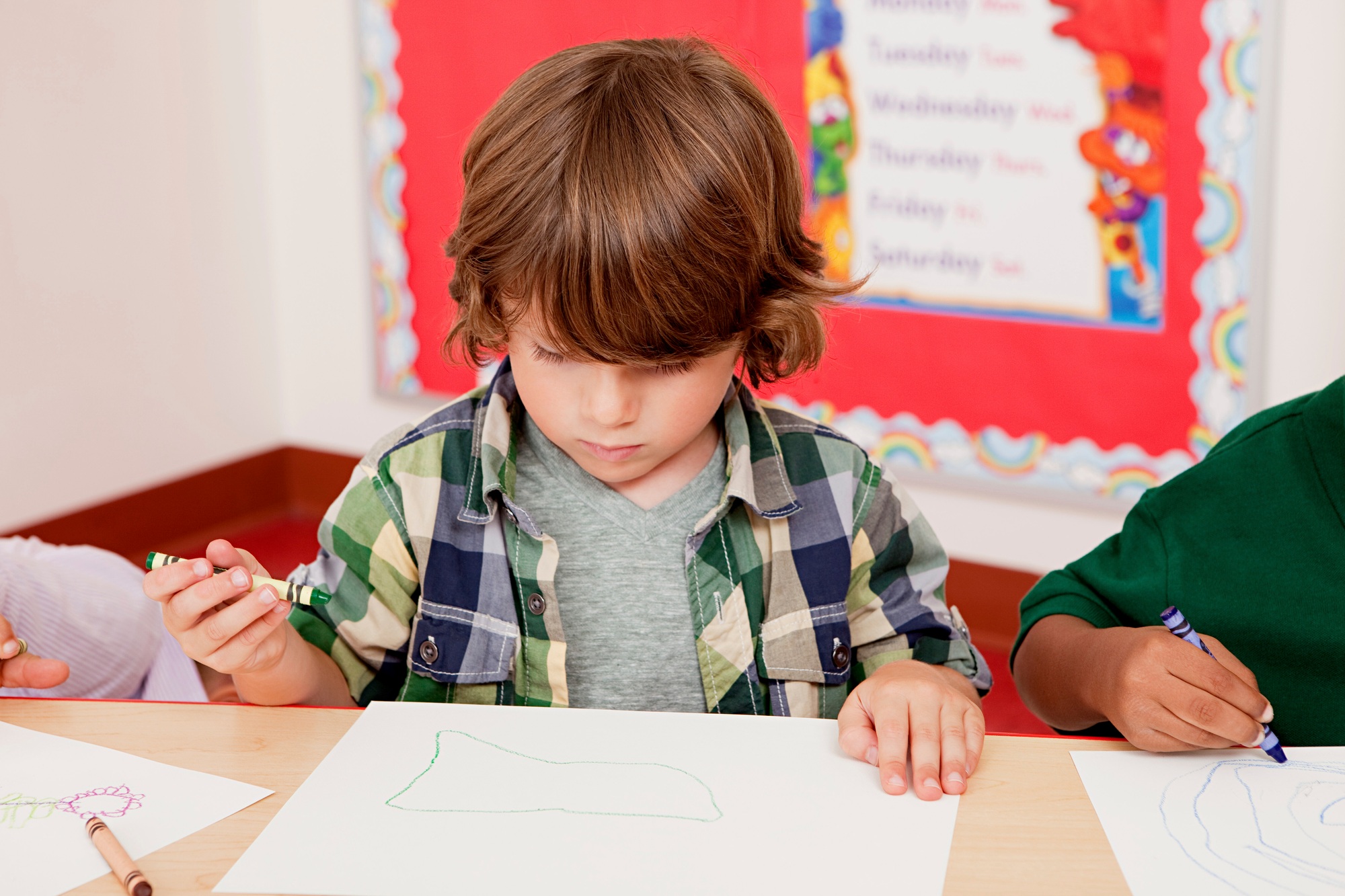 Boy drawing a picture in class