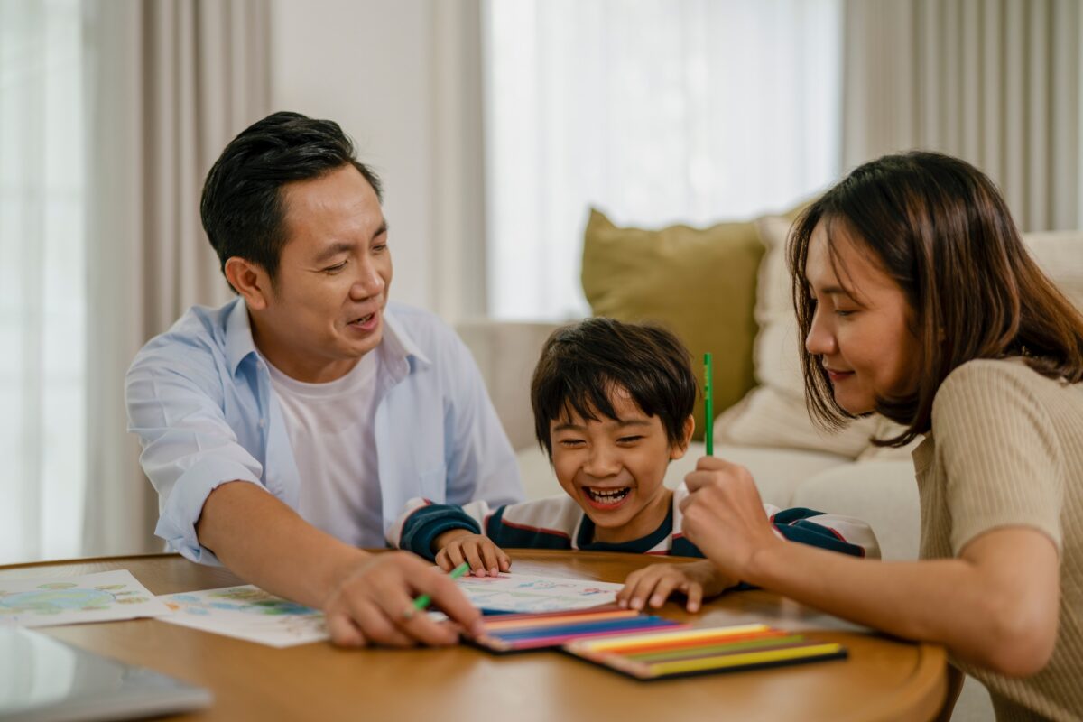 Father, mother and son drawing and coloring on vacation