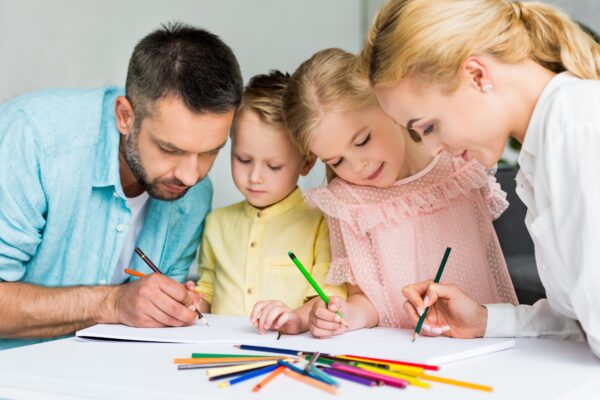 happy family drawing with colored pencils together at home