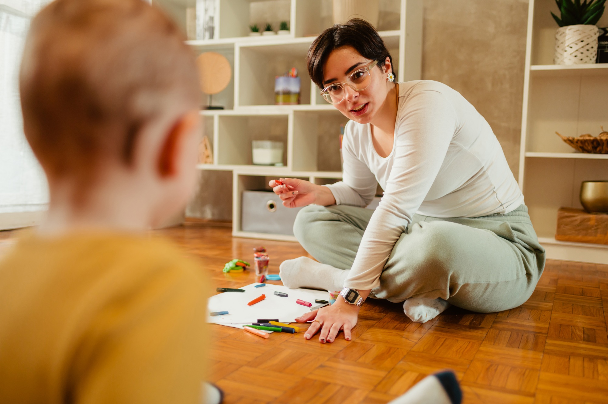 Mother and son drawing with crayons at home and creating art